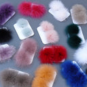 May include: A collection of colorful fur pom-poms, each attached to a white rectangular base. The pom-poms come in various shades, including pink, red, blue, green, and purple. The image is taken from a top-down perspective, showcasing the assortment.